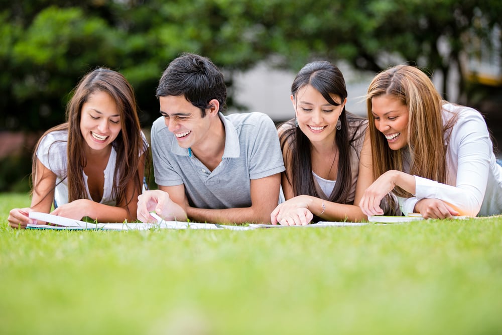 Group of students outdoors studying and looking happy