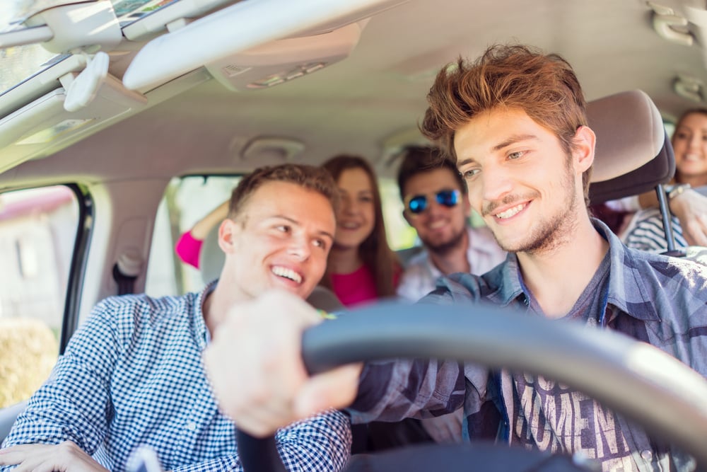 Young people having vacation enjoying fun driving car